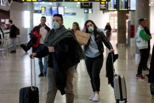 Travelers coming from Italy arrive at Manises airport with facial masks, in Valencia, eastern Spain, 25 February 2020. Two men who were recently in Milan are under inquiry at Vila-Real's Plana Hospital for a possible coronavirus infection. EFE/ Biel Alino