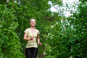 young fitness woman running at forest trail