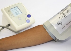 Woman checking blood pressure and heart rate with a digital blood pressure monitor